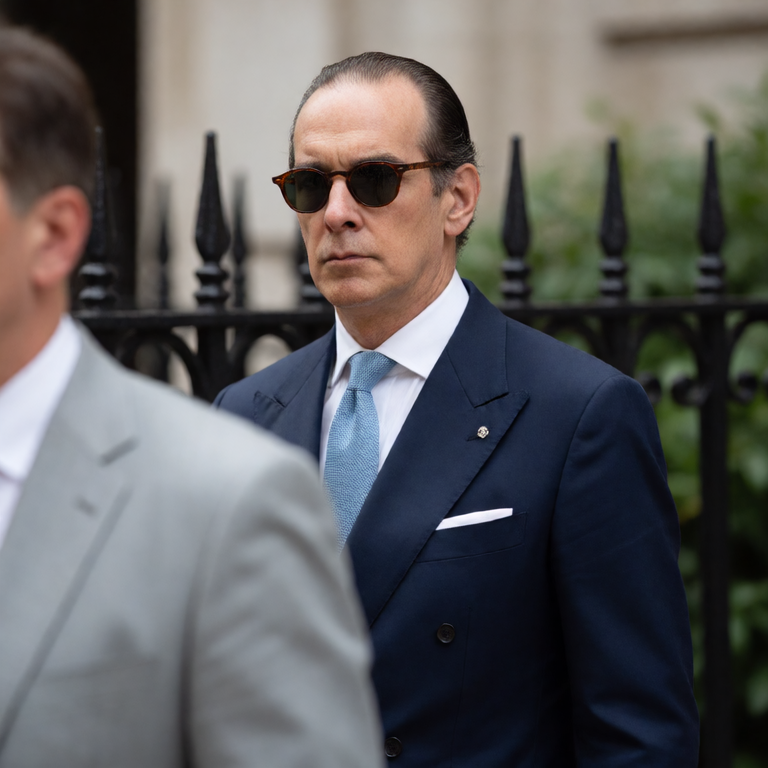Gesicht & Fiktion #20261021-101142 – KI-generiertes Bild: Photorealistic candid press photograph of a slim middle-aged man with slicked-back thinning dark hair and a tanned complexion, wearing dark tortoiseshell round sunglasses, a tai…